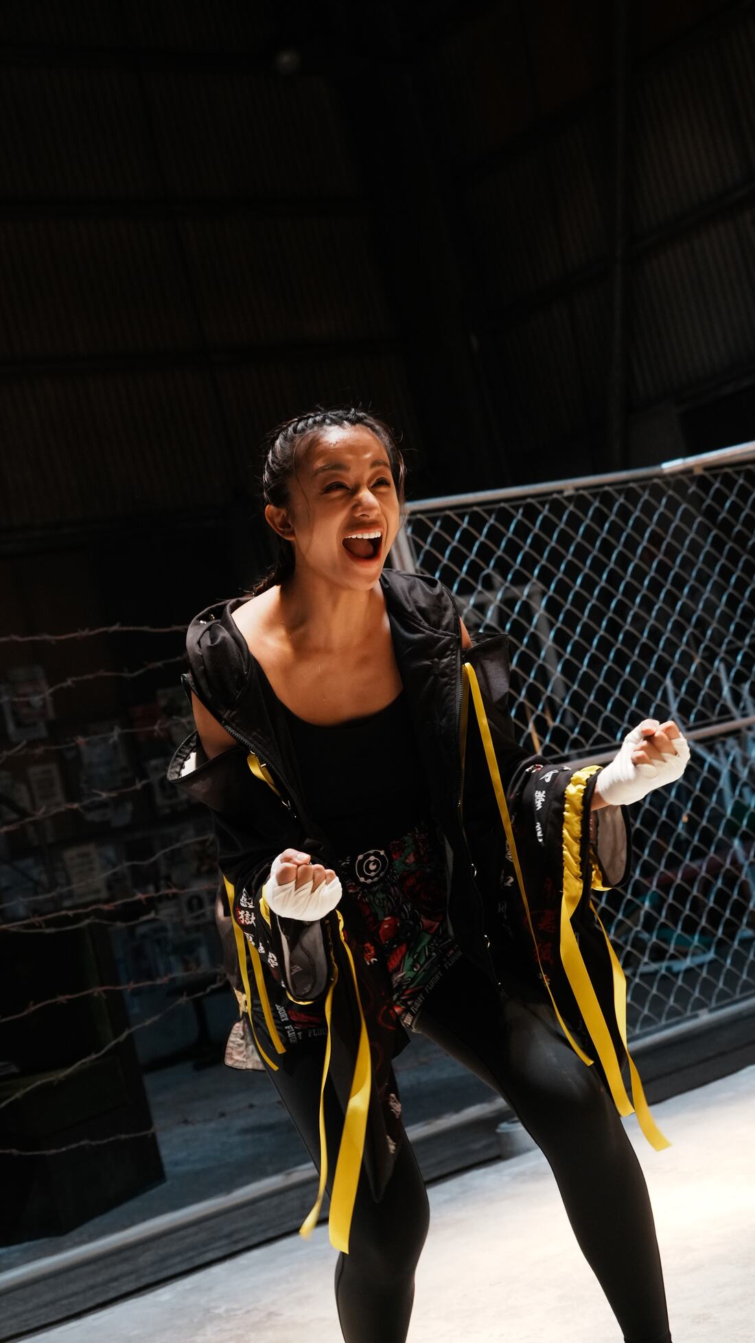 Saki in her black and gold robe inside the cage